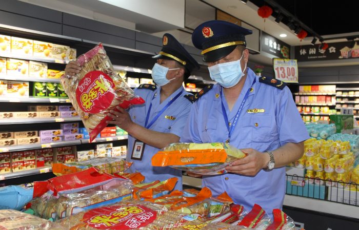 圖為該局執(zhí)法人員在一家農(nóng)村超市查看食品包裝。
