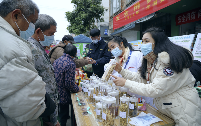 圖為工作人員現(xiàn)場向群眾講解常用中藥材的鑒別知識，普及藥品安全相關(guān)法律法規(guī)。