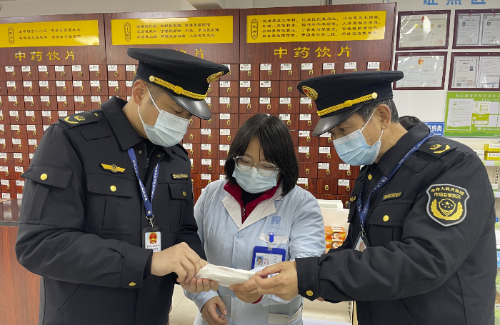 圖為該局執(zhí)法人員在一家零售藥店檢查醫(yī)用口罩。