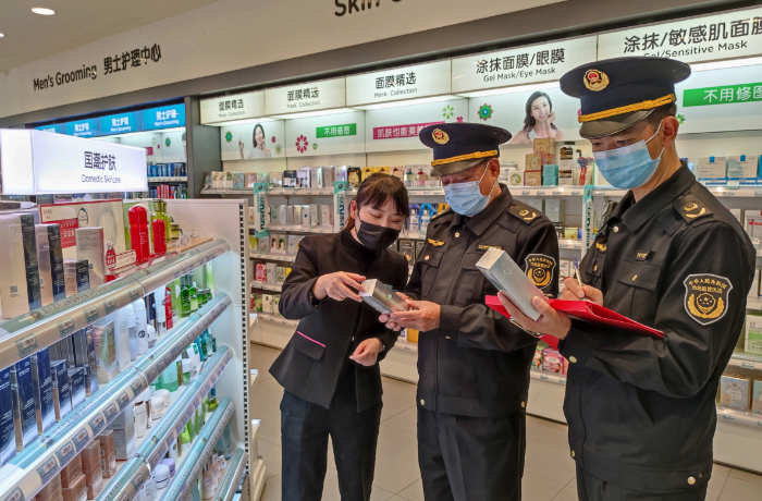 圖為該局執(zhí)法人員在一家化妝品專賣店檢查潤膚霜產(chǎn)品說明。