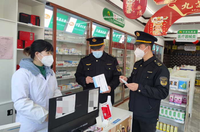 圖為該局執(zhí)法人員在一家零售藥店檢查新冠病毒抗原檢測試劑質(zhì)量。