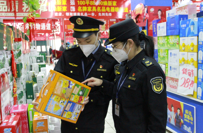 圖為該局執(zhí)法人員在一家商場檢查在售食品是否超過保質(zhì)期。