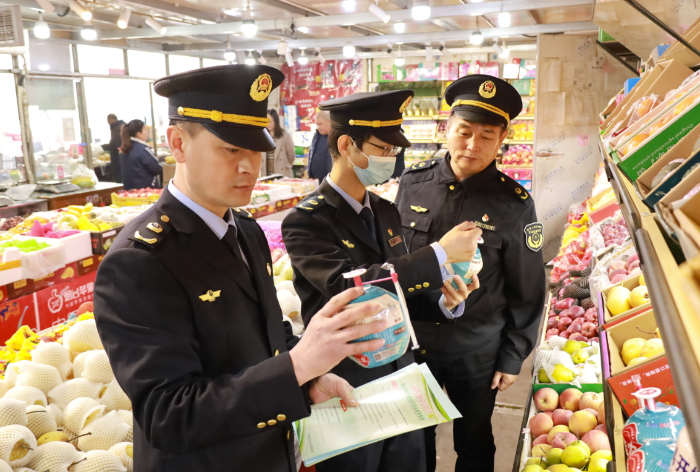 圖為武清區(qū)市場監(jiān)管局執(zhí)法人員在農(nóng)貿(mào)市場檢查食品是否在保質(zhì)期內(nèi)。