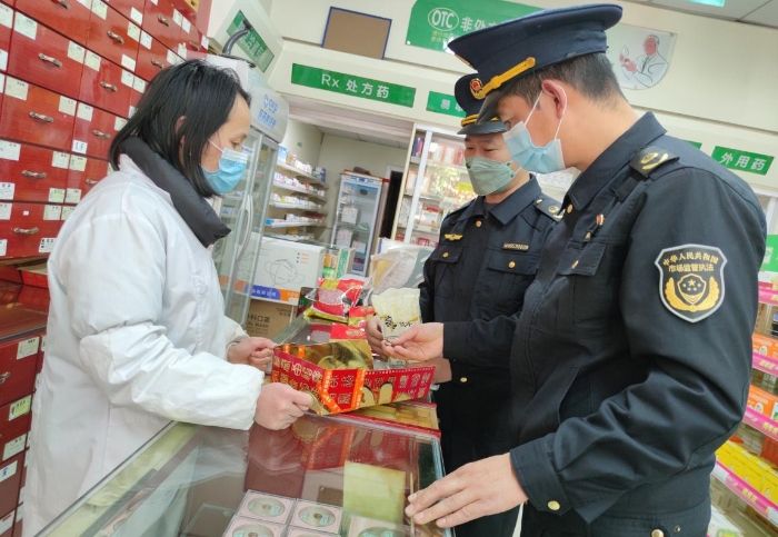 圖為執(zhí)法人員在一家零售藥店檢查中藥飲片是否霉?fàn)€變質(zhì)。