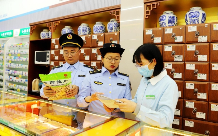 圖為4月25日，執(zhí)法人員在對(duì)一家零售藥店的中藥飲片進(jìn)行檢查。