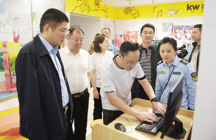 圖為湖南省藥監(jiān)局副局長覃永忠（左一）查看化妝品經(jīng)營戶產(chǎn)品質(zhì)量臺賬。