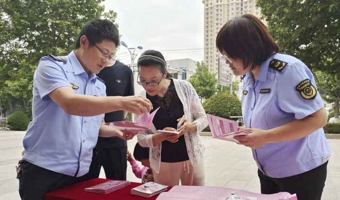 圖為該局工作人員向群眾發(fā)放化妝品科普宣傳資料。