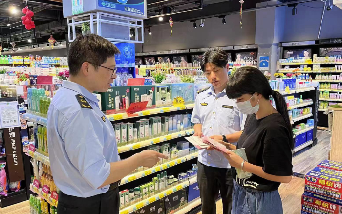 圖為該局工作人員在商場(chǎng)向群眾宣傳化妝品安全知識(shí)。