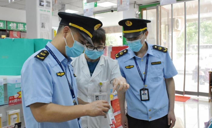 圖為該局執(zhí)法人員正在轄區(qū)內(nèi)一家藥店檢查核對相關(guān)藥品銷售信息。