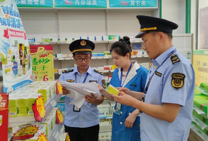 圖為6月5日?qǐng)?zhí)法人員在一家藥店檢查防暑藥品質(zhì)量情況。