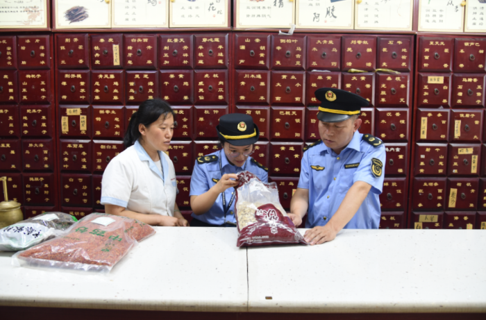 圖為該局執(zhí)法人員在一家藥品零售企業(yè)檢查在售中藥飲片質(zhì)量。