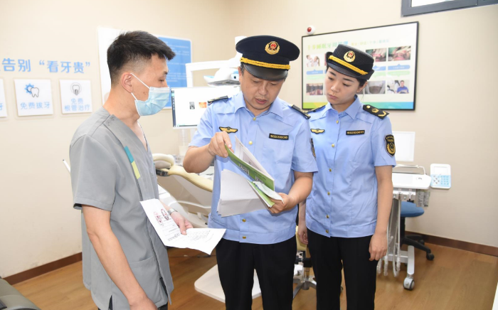 圖為該局執(zhí)法人員在一家口腔診所檢查其藥械采購索證索票情況。