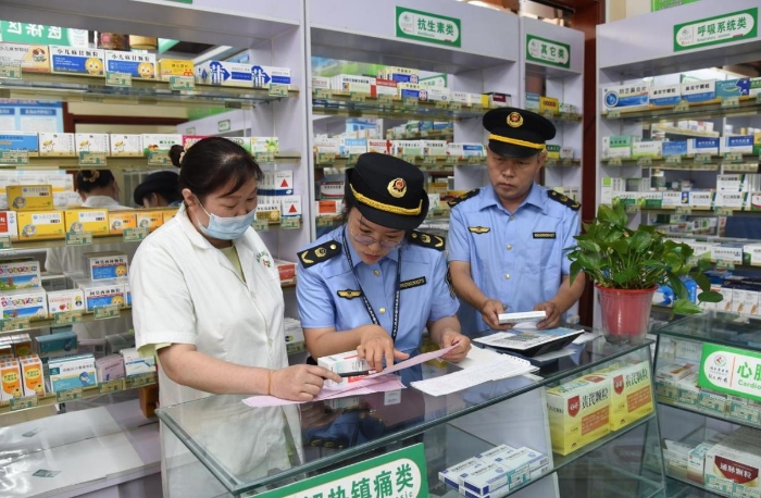 圖為執(zhí)法人員在一家藥品零售企業(yè)檢查藥品購進渠道情況。