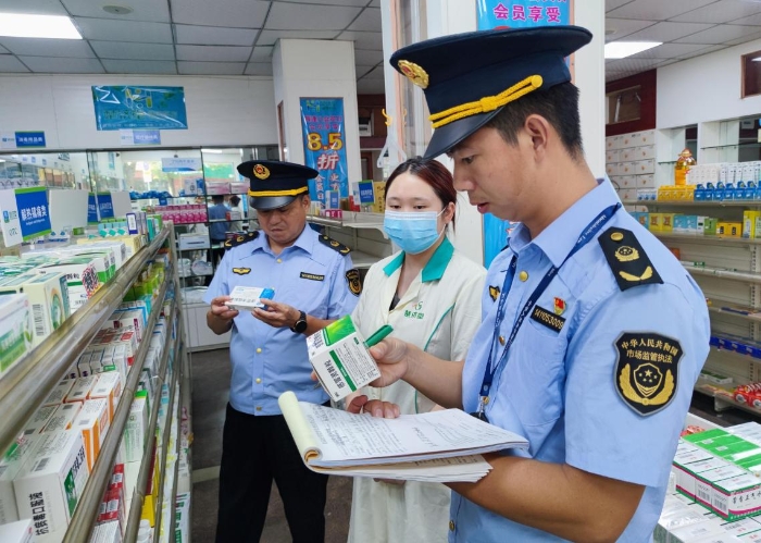 圖為執(zhí)法人員在一家藥店檢查抗病毒藥品質(zhì)量。