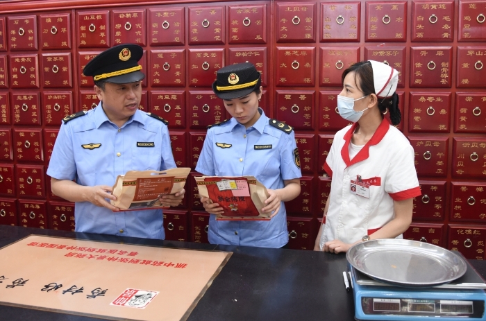 圖為執(zhí)法人員正在一家藥品經(jīng)營企業(yè)抽檢中藥飲片。