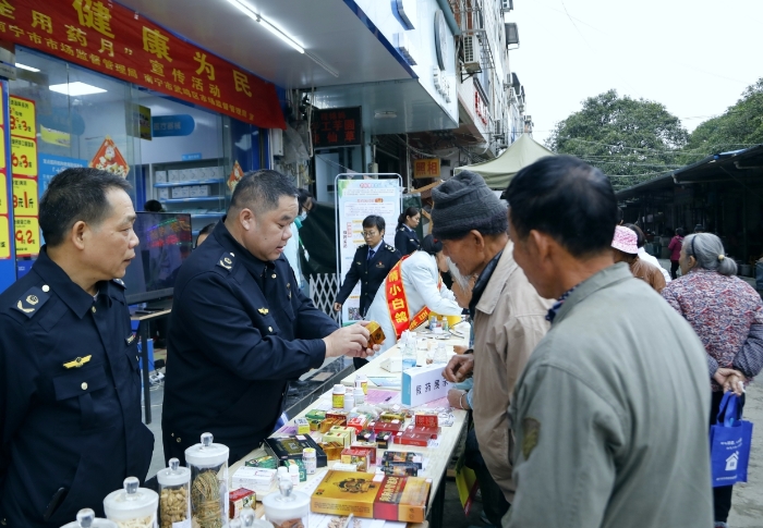 市場(chǎng)監(jiān)管部門工作人員向公眾介紹如何識(shí)別假冒偽劣藥品。（何正君 攝）