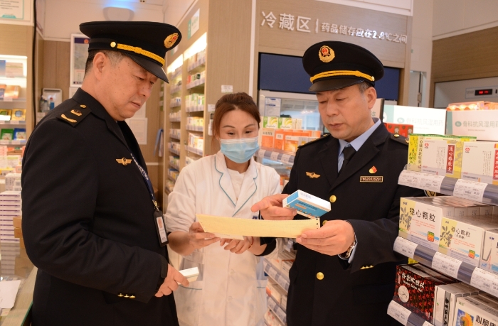 圖為執(zhí)法人員在一家藥品經(jīng)營企業(yè)檢查抗病毒藥品的購進情況。