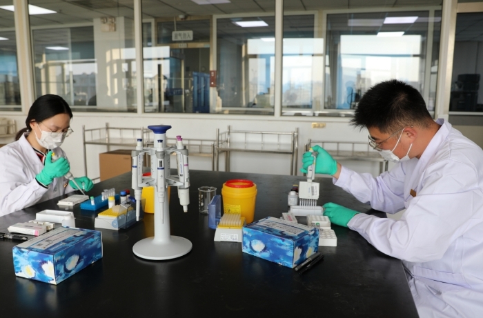 圖為檢驗(yàn)人員對(duì)企業(yè)送檢藥品應(yīng)急檢驗(yàn)。