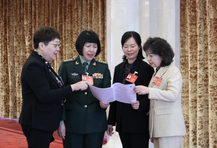 圖為全國政協(xié)醫(yī)衛(wèi)界別部分委員在小組會(huì)議結(jié)束后，繼續(xù)討論政府工作報(bào)告內(nèi)容。