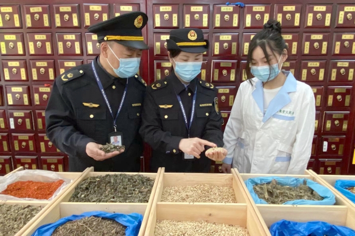 圖為執(zhí)法人員檢查中藥飲片。