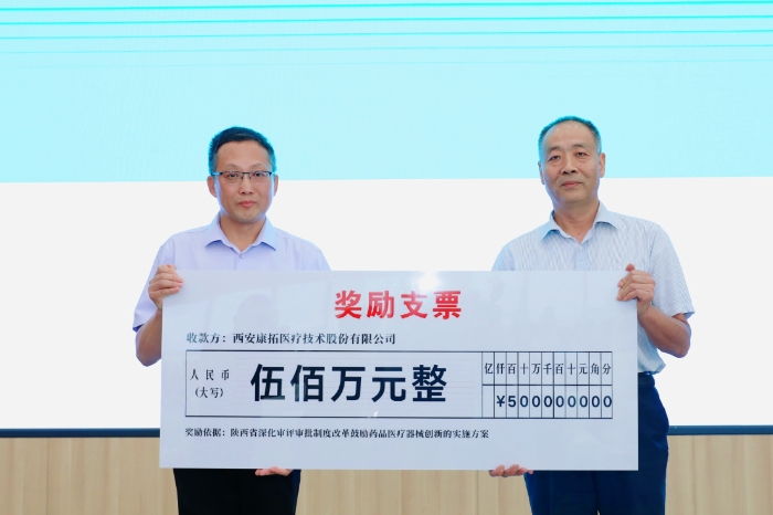 圖為研討會現(xiàn)場，陜西省藥監(jiān)局二級巡視員王志宏向西安康拓醫(yī)療技術(shù)股份有限公司董事長胡立人頒發(fā)500萬元醫(yī)療器械創(chuàng)新獎(jiǎng)勵(lì)資金。