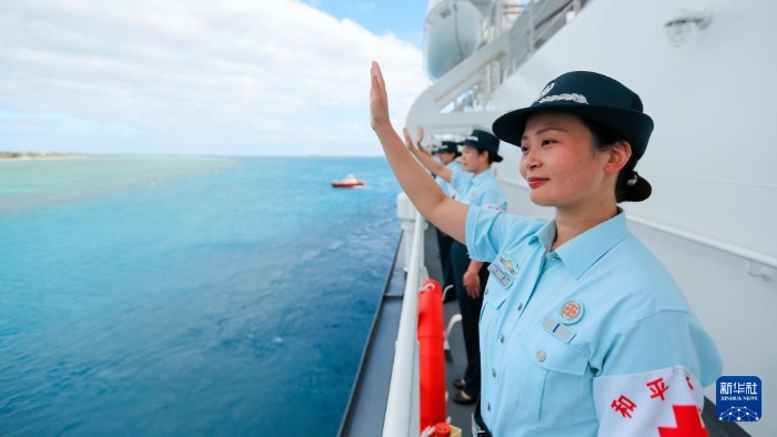 中國(guó)海軍“和平方舟”號(hào)醫(yī)院船結(jié)束訪問(wèn)湯加時(shí)，任務(wù)官兵中的文職人員向歡送人群揮手告別（2023年8月4日攝）。新華社發(fā)（徐巍 攝）