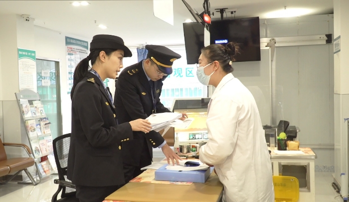 圖為該局執(zhí)法人員檢查安禾綜合門診部疫苗采購、運輸和儲存記錄單。